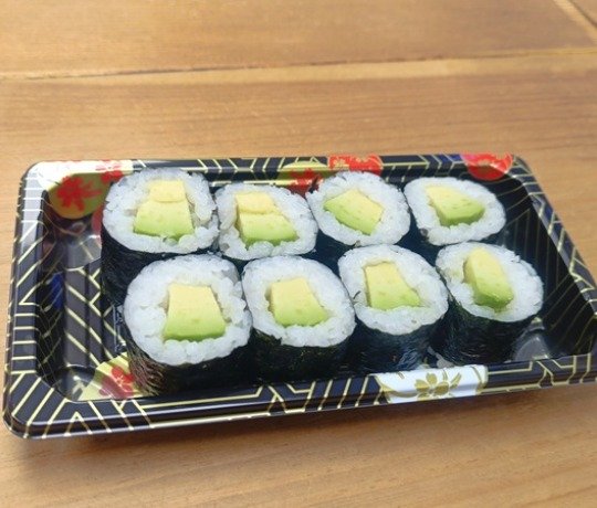Avocado maki sushi roll A beautifully arranged tray of avocado maki sushi rolls.
